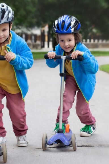 To søde børn der står på løbehjul